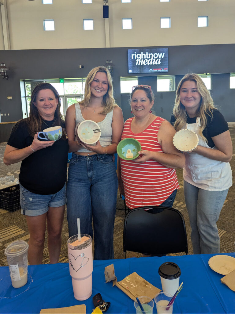 Four women holding hand-painted bowls at the Carbon Valley Help Center Empty Bowls fundraiser.