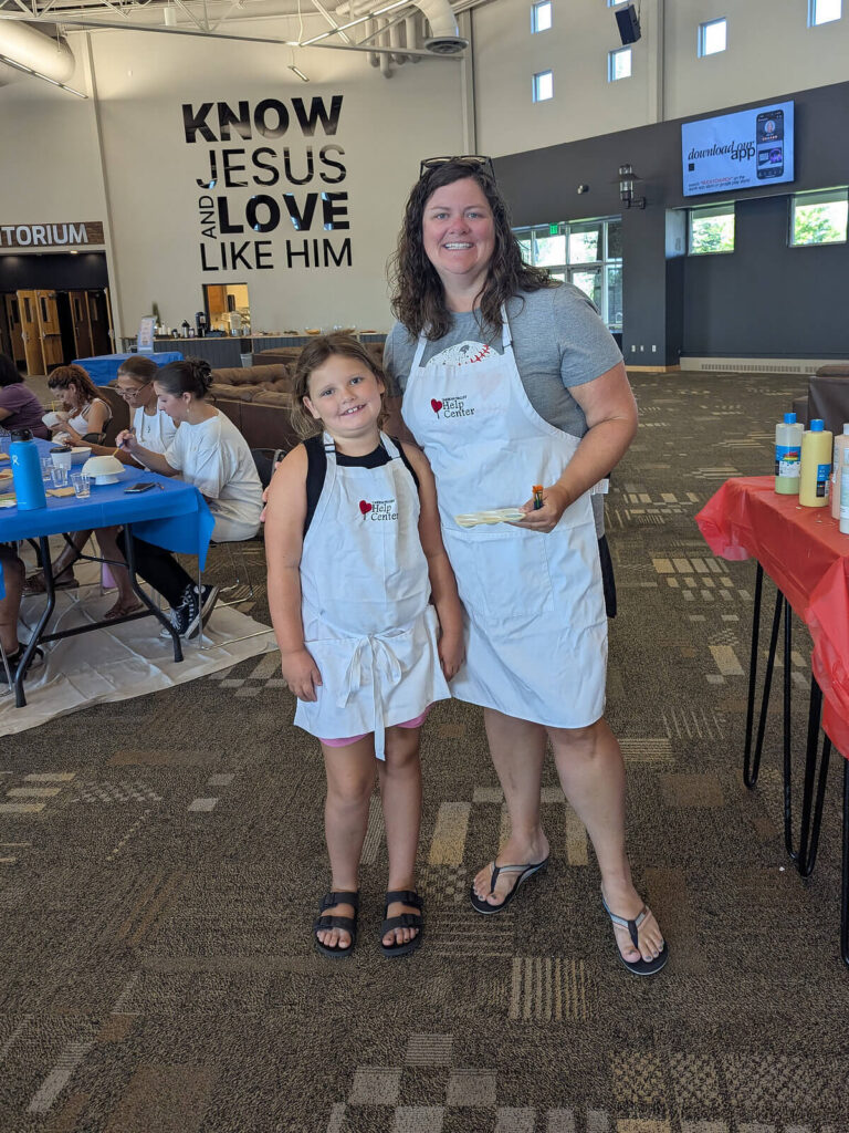 Mother and daughter wearing Carbon Valley Help Center aprons at the Empty Bowls fundraiser.